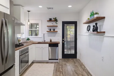 a kitchen with a sink a refrigerator and cabinets
