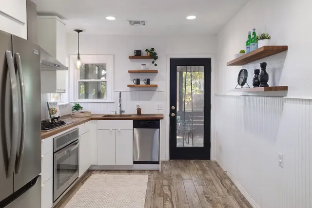 a kitchen with a sink a refrigerator and cabinets