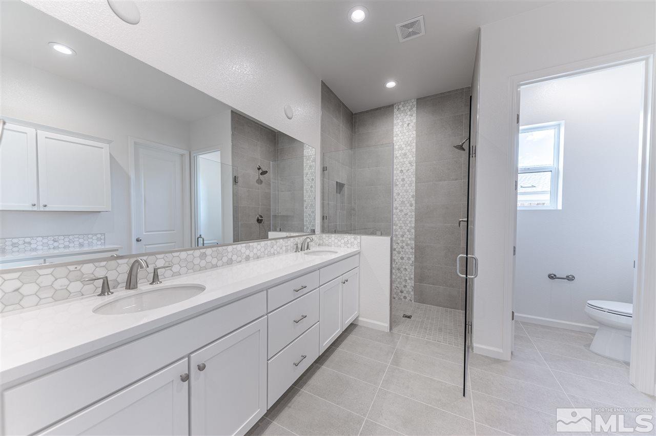 12245 Pewter Point Street, Unit HOMESITE 40 Reno, NV 89521 - Photo 8 of 10 a bathroom with a double vanity sink toilet and shower