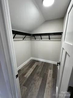 a view of walk in closet with wooden floor