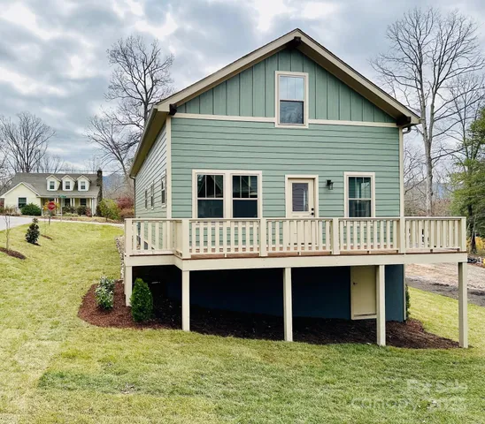 a front view of a house with a yard balcony and seating space