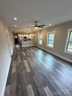 a view of a hallway with wooden floor and windows