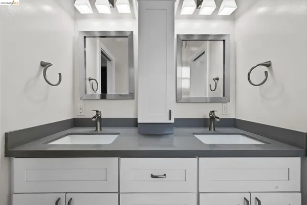 a bathroom with double vanity sinks and a mirror