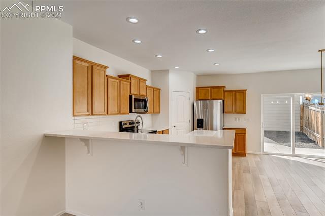 6338 Pilgrimage Road Colorado Springs, CO 80925 - Photo 9 of 28 Quartz Countertops, Stainless Appliances, Designer Backsplash and Plumbing Fixtures