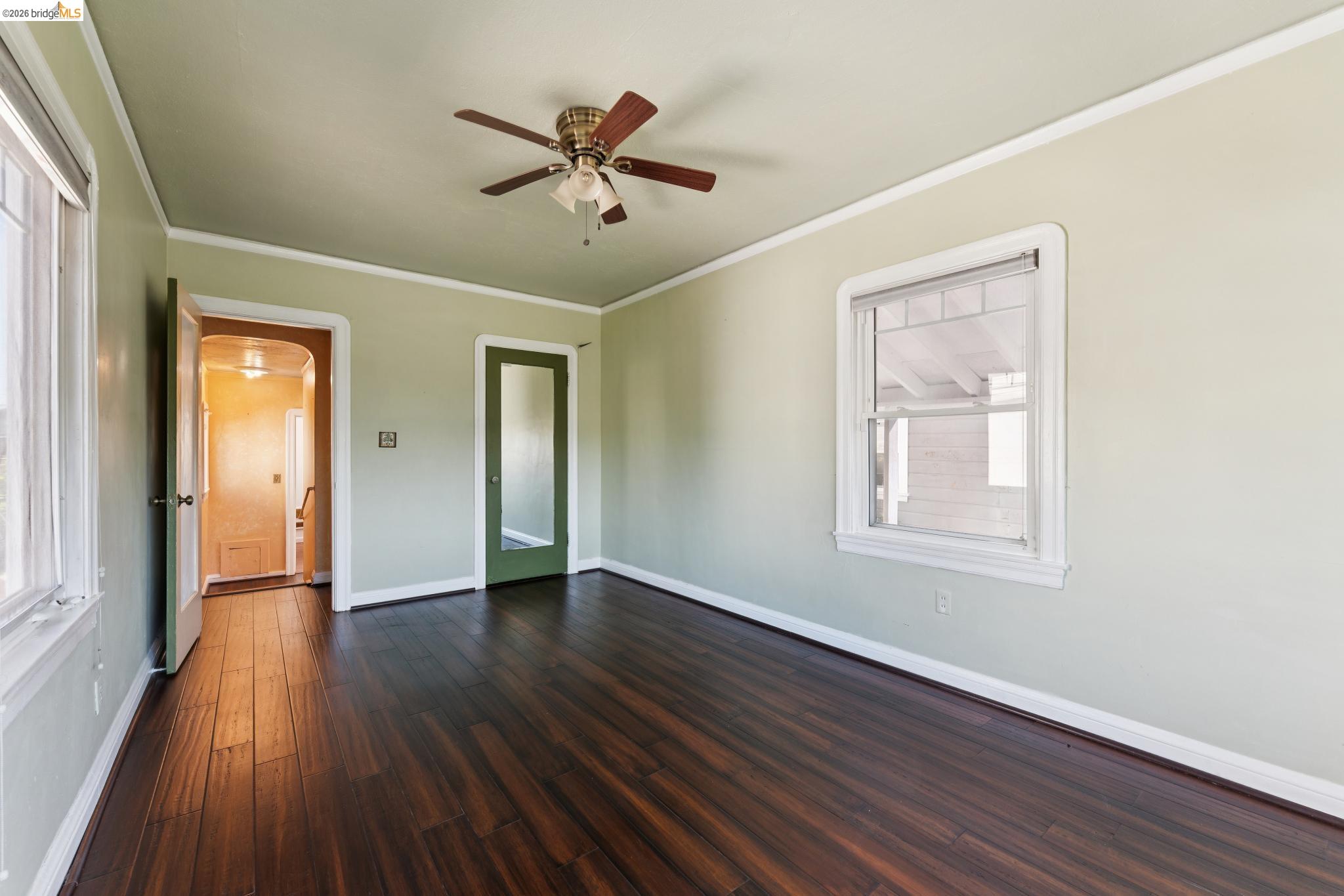 978 43rd Street Oakland, CA 94608 - Photo 27 of 46 Spacious interior room featuring rich wood-finish flooring, light green wall paint, and white trim