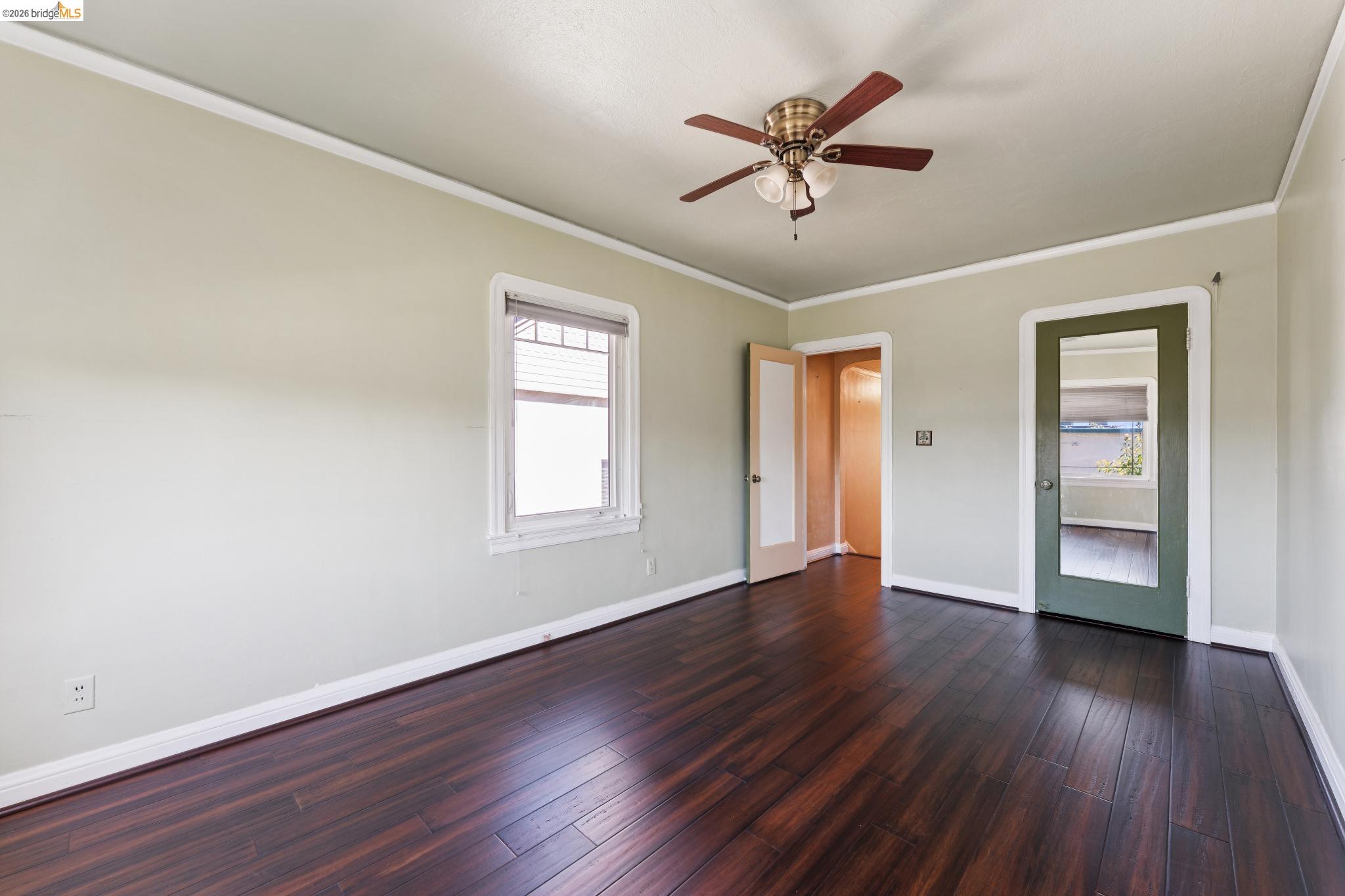 978 43rd Street Oakland, CA 94608 - Photo 28 of 46 Room featuring wood-finish flooring, a ceiling fan with light kit, a window with blinds, and light green painted walls with white trim