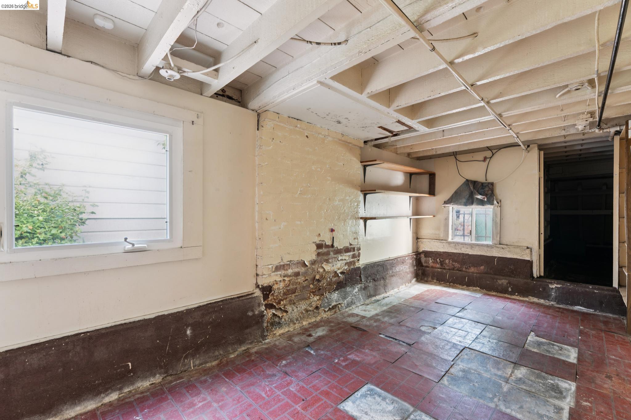 978 43rd Street Oakland, CA 94608 - Photo 35 of 46 Exposed ceiling joists with visible wiring, a window providing natural light, and brick flooring