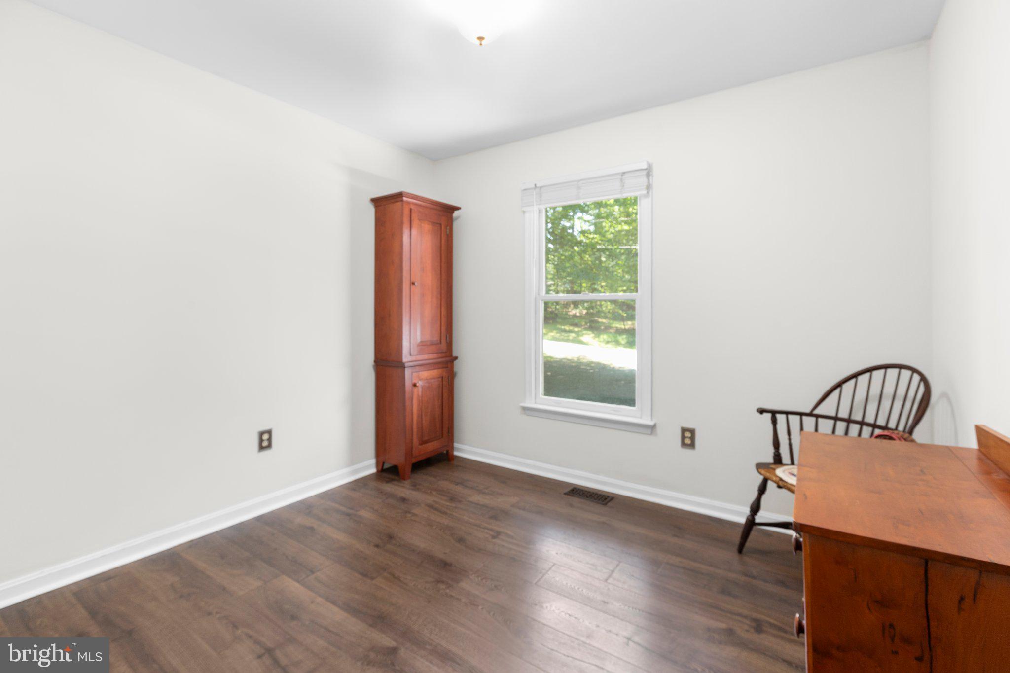 228 Cedar Ridge Drive Ruther Glen, VA 22546 - Photo 29 of 77 a view of an empty room with wooden floor and a window