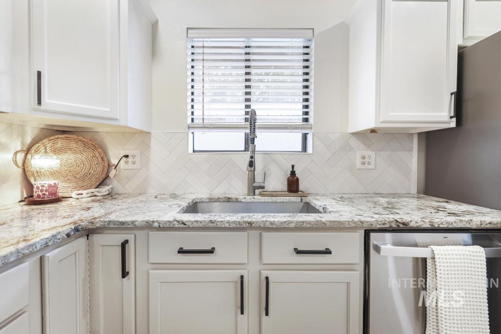 2243 4000 North Filer, ID 83328 - Photo 6 of 30 Kitchen featuring stainless steel dishwasher, white cabinetry, light stone counters, and tasteful backsplash