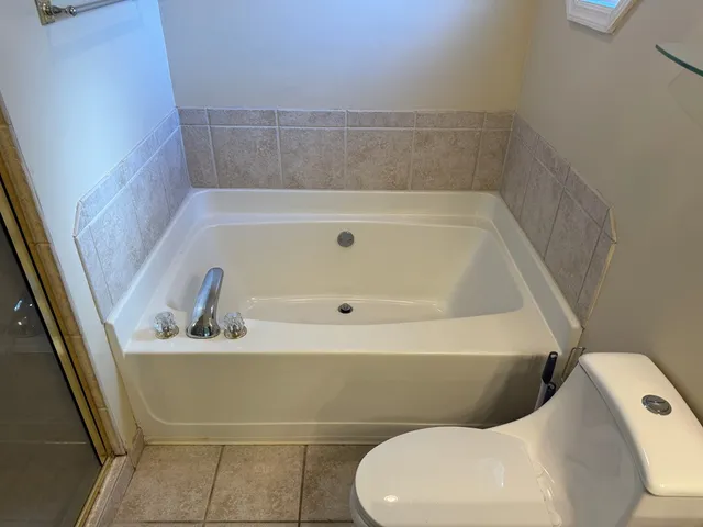 a bathroom with a tub and toilet