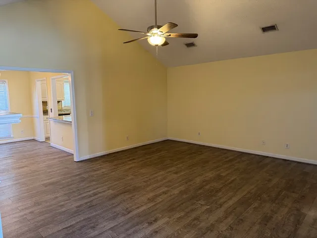 a view of a kitchen with wooden floor and a chandelier fan