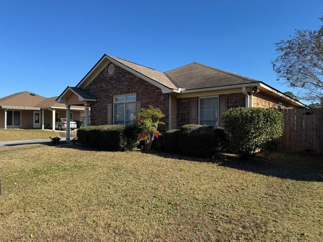 a front view of a house with yard and green space