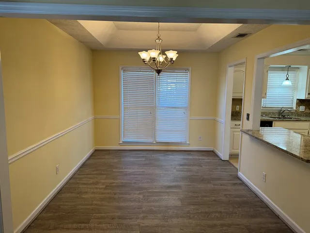 a view of a room with wooden floor and chandelier