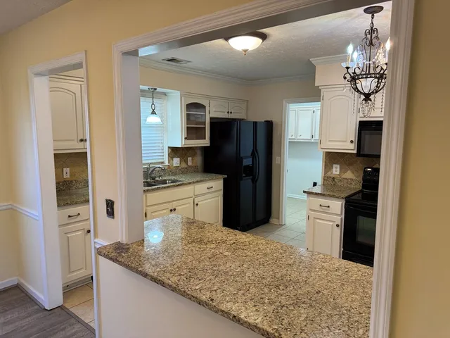 a kitchen with stainless steel appliances granite countertop a refrigerator a stove and a sink