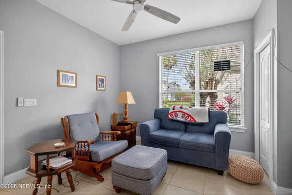 a living room with furniture a flat screen tv and a large window