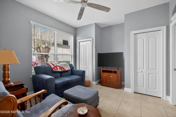 a living room with furniture kitchen view and a chandelier