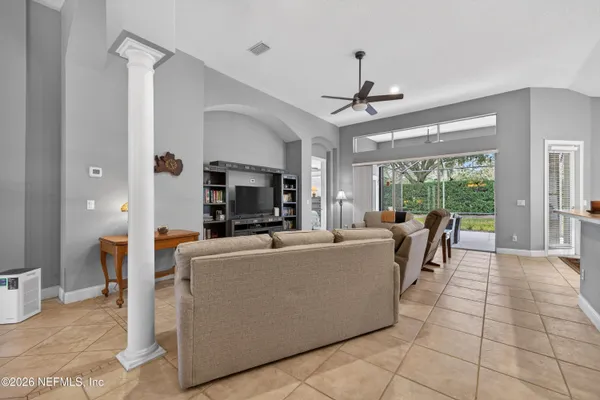 a living room with furniture a fireplace and a chandelier
