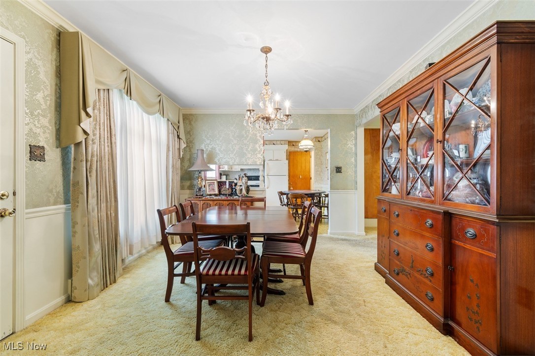 3265 Ridgewood Road Akron, OH 44333 - Photo 10 of 29 Carpeted dining room with an inviting chandelier and ornamental molding