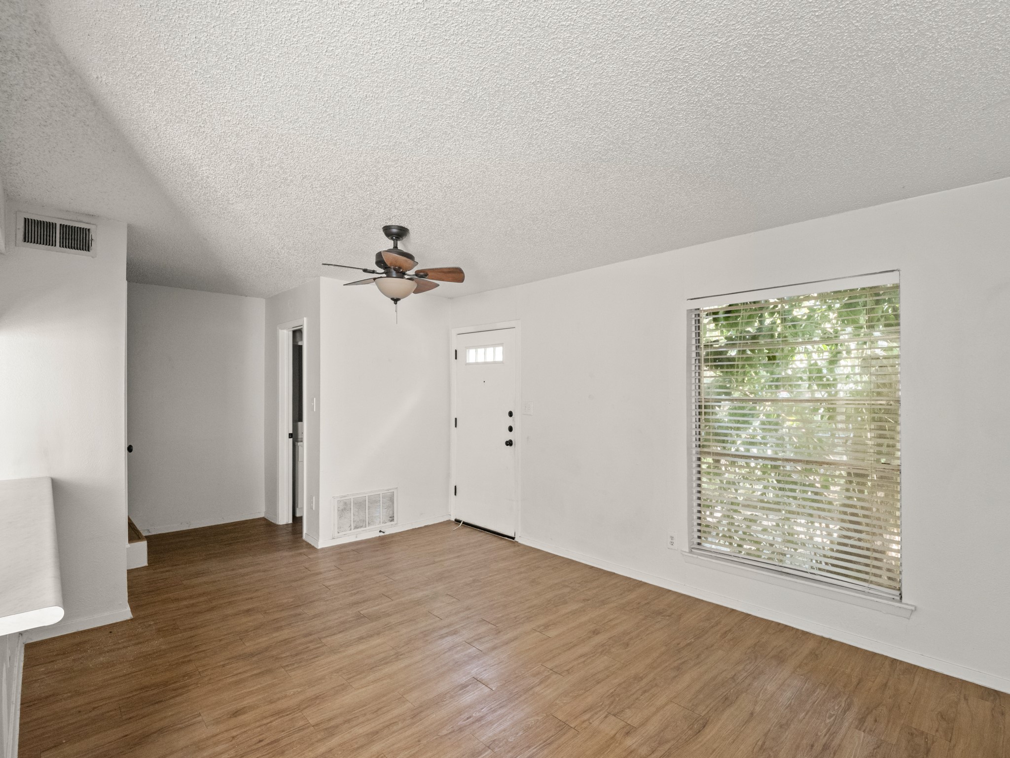 3507 Alpine Circle Austin, TX 78704 - Photo 18 of 30 an empty room with wooden floor chandelier fan and windows