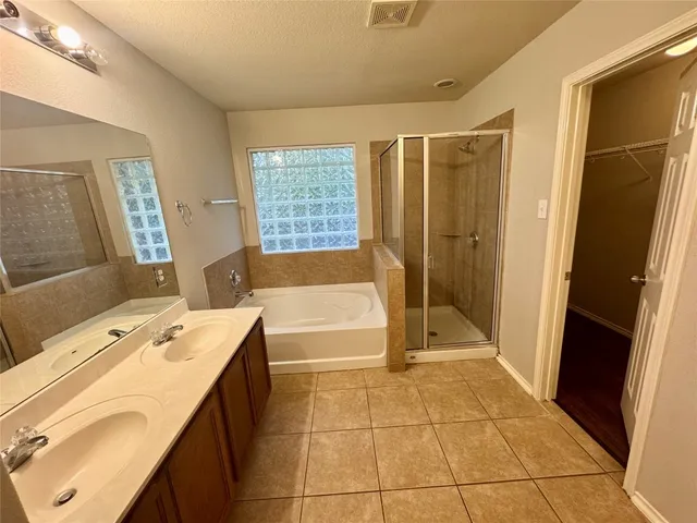 a spacious bathroom with a tub sink and a mirror
