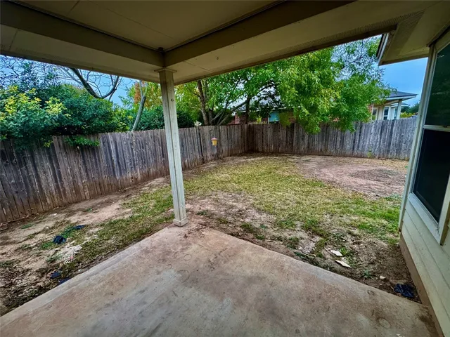 a backyard with large trees and wooden fence