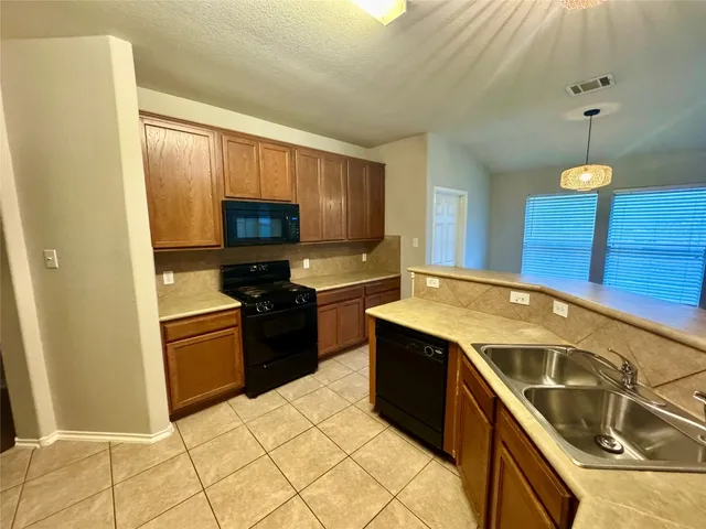 a kitchen with a sink a stove top oven and cabinets