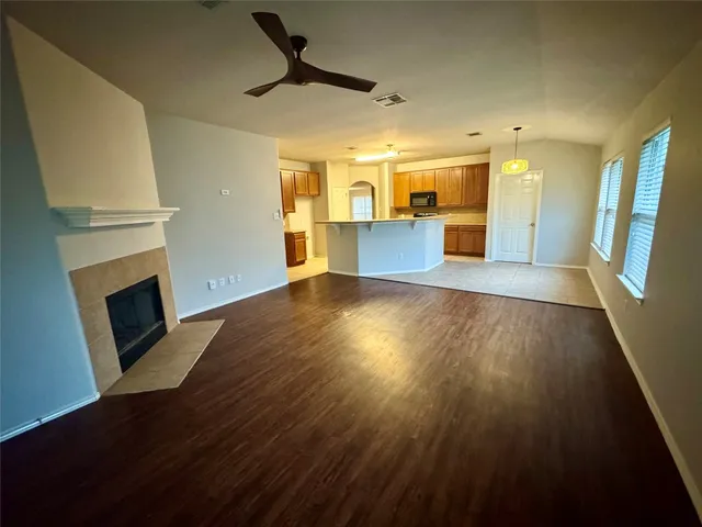 a view of a livingroom with wooden floor and a fireplace