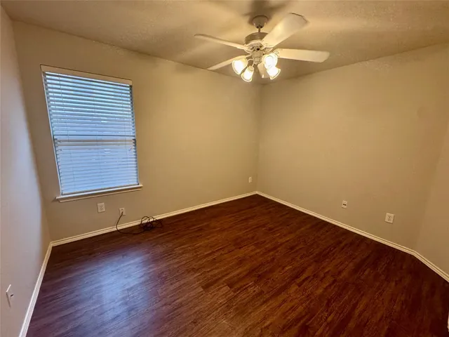 a view of a room with wooden floor and a window