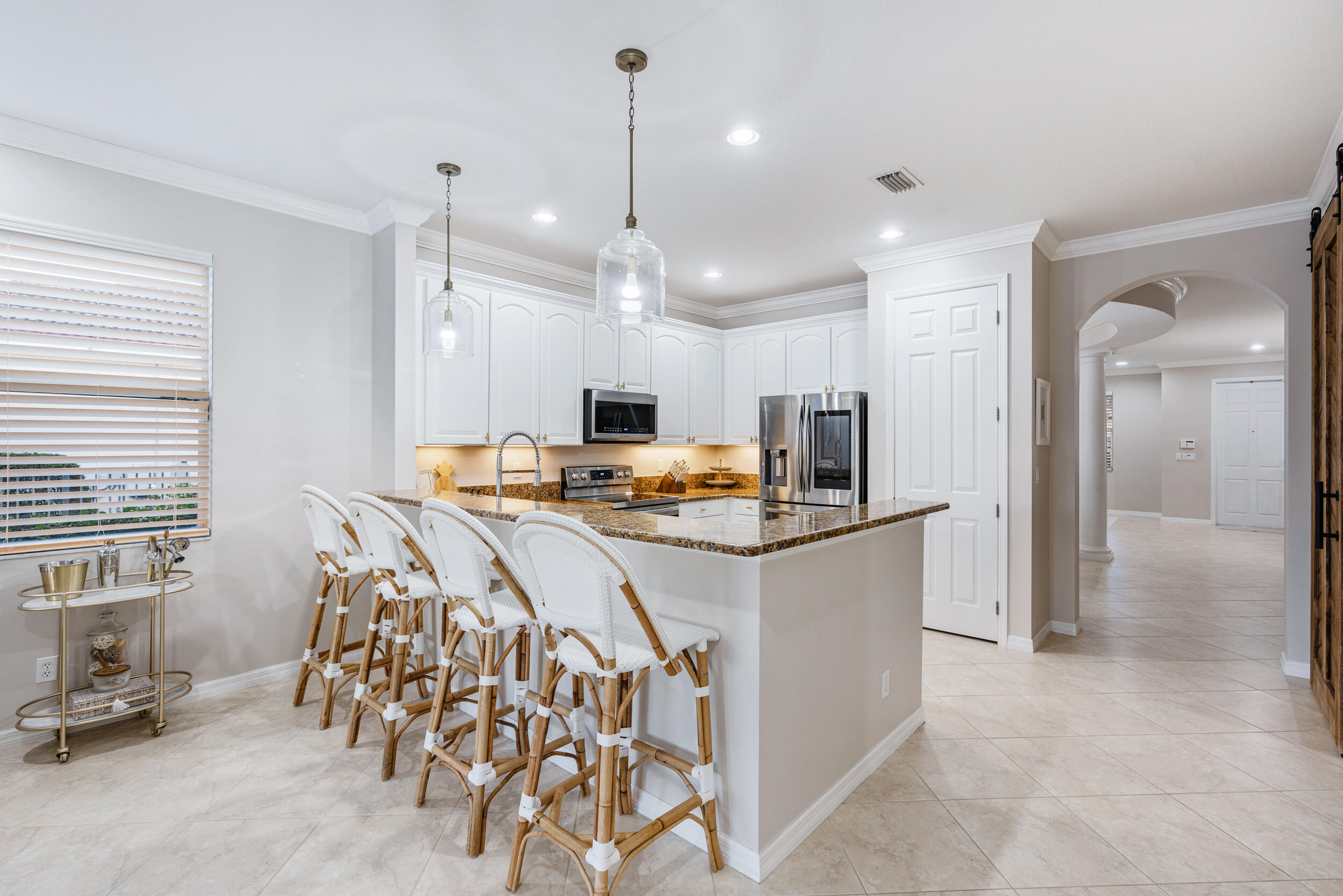 237 Porgee Rock Place Jupiter, FL 33458 - Photo 15 of 47 a kitchen with stainless steel appliances kitchen island granite countertop a refrigerator and a sink