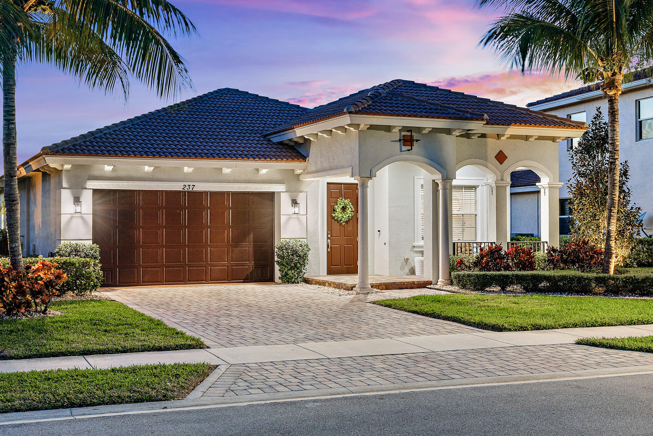 237 Porgee Rock Place Jupiter, FL 33458 - Photo 2 of 47 a front view of a house with a garden