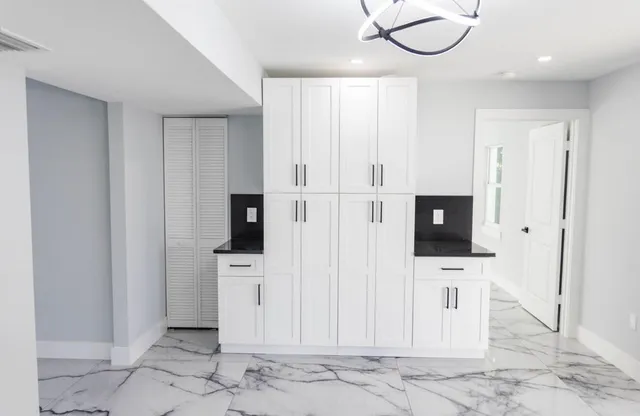 a kitchen with stainless steel appliances granite countertop a sink and a refrigerator
