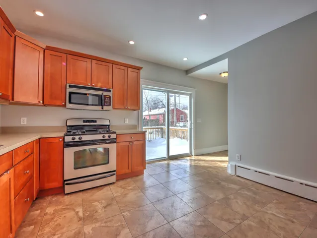 a kitchen with stainless steel appliances granite countertop a stove a sink and a microwave