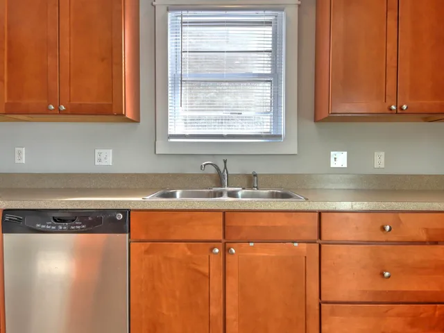a kitchen with granite countertop cabinets stainless steel appliances and a sink