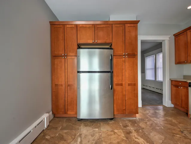 a view of a kitchen with wooden floor and a refrigerator