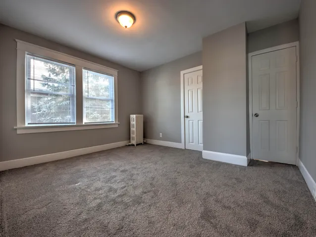 an empty room with windows and closet