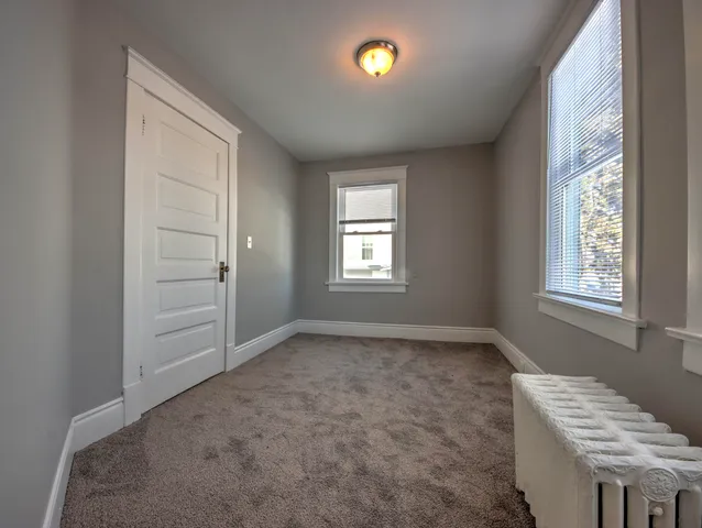 an empty room with windows and closet