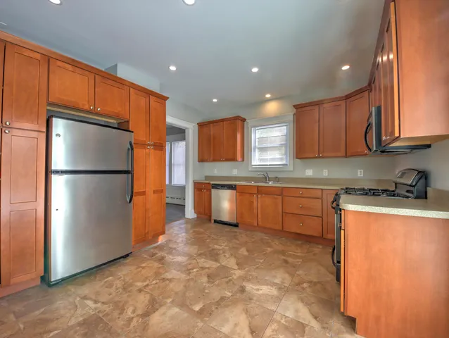 a kitchen with granite countertop a refrigerator and a sink