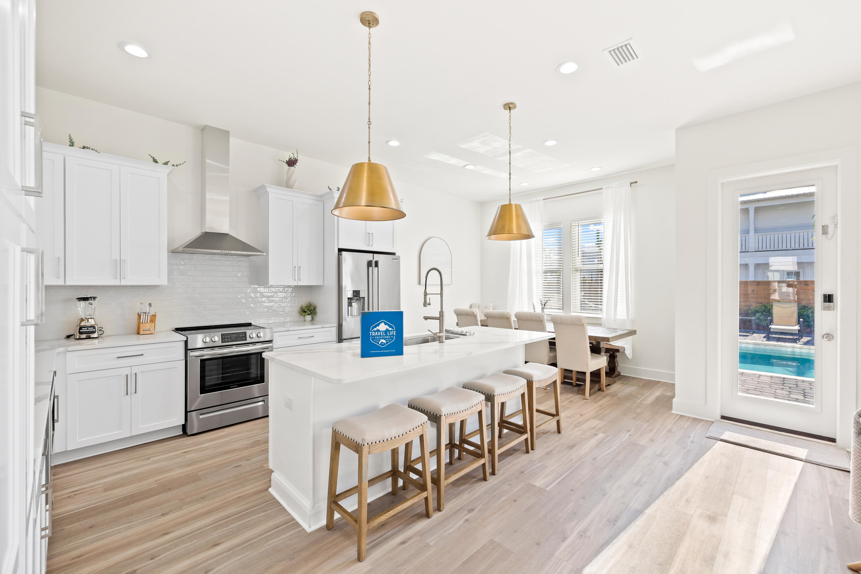 7 Lake Street Miramar Beach, FL 32550 - Photo 13 of 37 a large kitchen with lots of counter space dining table and stainless steel appliances