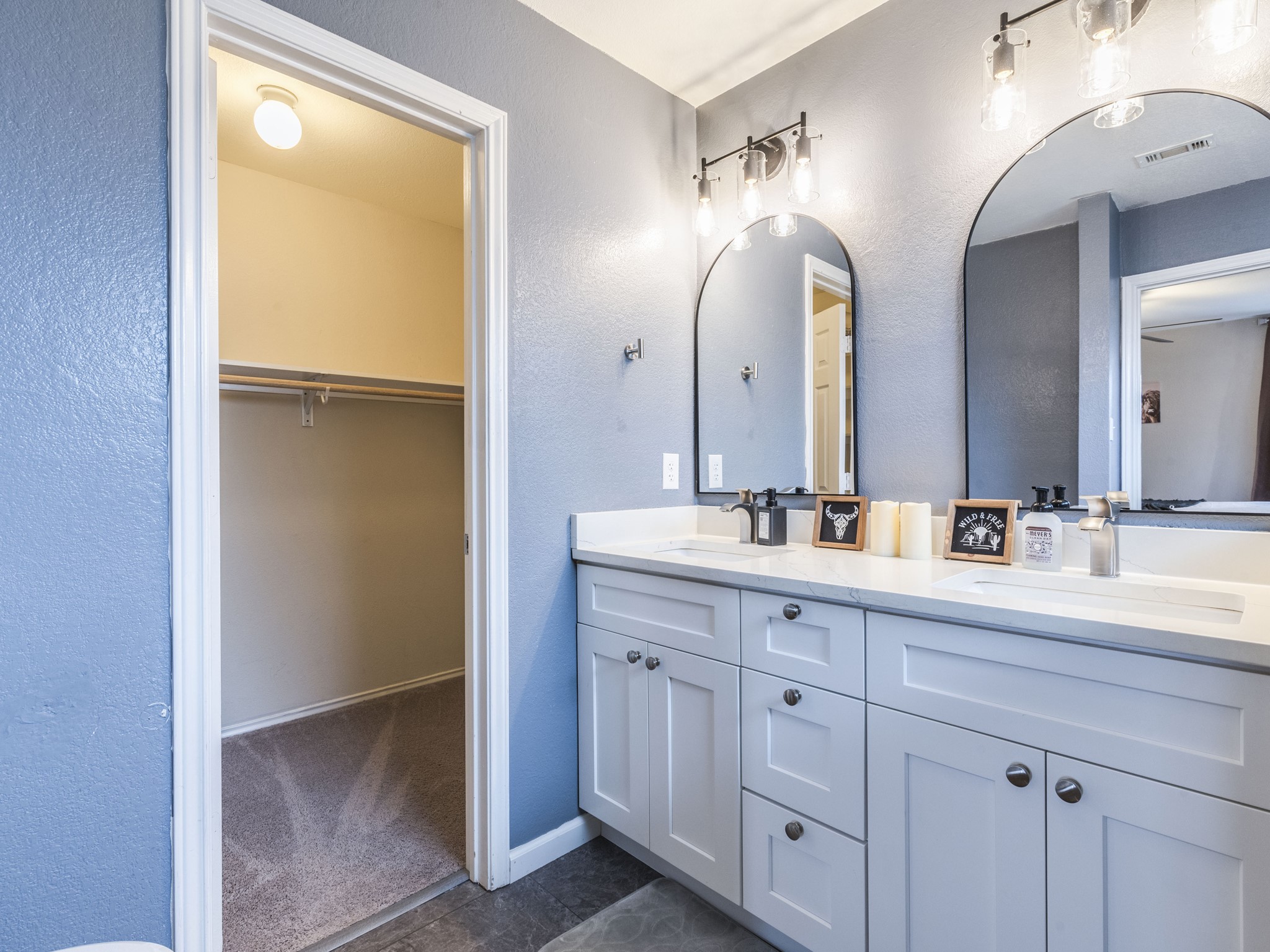 1415 Roxanne's Run Pflugerville, TX 78660 - Photo 19 of 30 Double vanities with sleek arch mirrors create a refined aesthetic in this inviting bathroom.