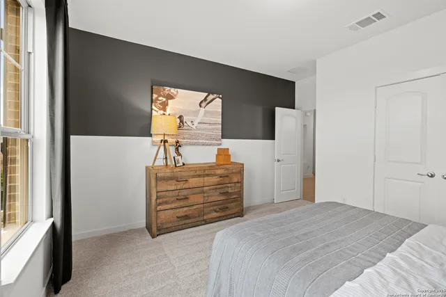 a bedroom with a bed and a flat tv screen on a dresser