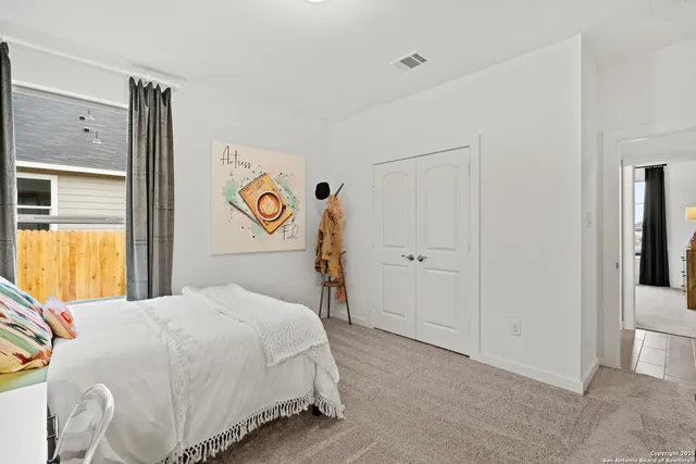 a bedroom with a bed and a refrigerator