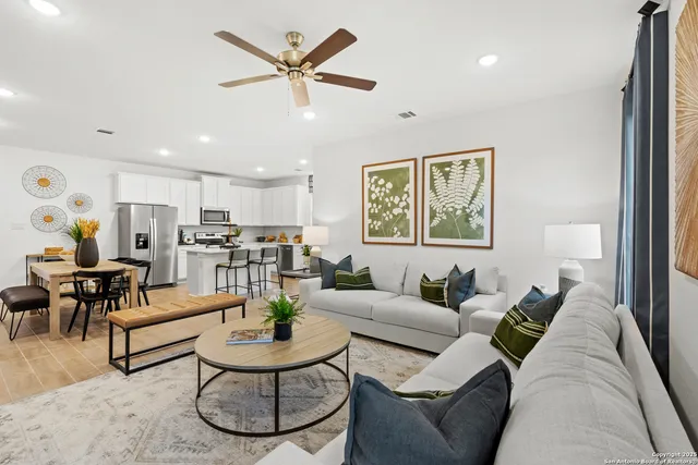 a living room with furniture a table and kitchen view