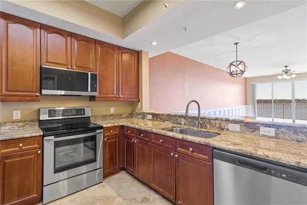 a kitchen with granite countertop a sink stainless steel appliances and cabinets