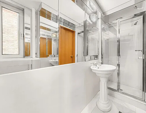 120 Central Park South, Unit 6AB Manhattan, NY 10019 - Photo 8 of 10 a bathroom with a sink a mirror and a bathtub