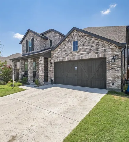 a front view of a house with a garden and garage