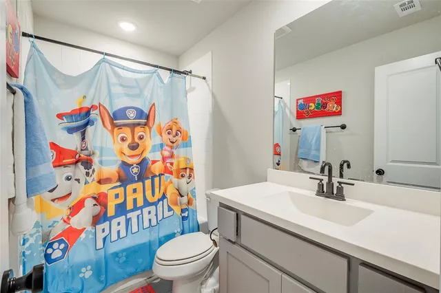 a bathroom with a sink a toilet and shower curtain