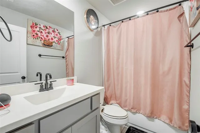 a bathroom with a sink mirror vanity and toilet