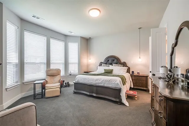 a bedroom with bed a lamp and a large window with the outer view