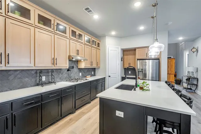 a kitchen with a sink refrigerator and cabinets