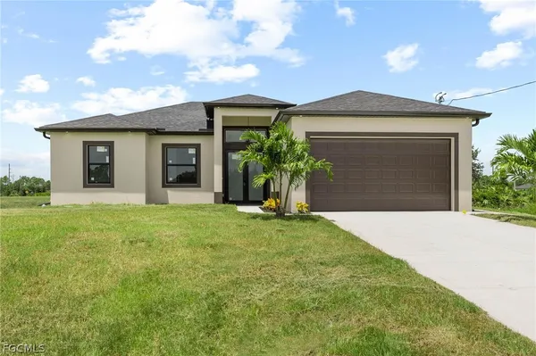 a front view of a house with a yard and garage